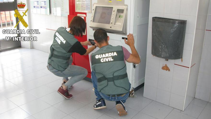 Agentes de la Guardia Civil revisan algunas de las máquinas manipuladas por el detenido.