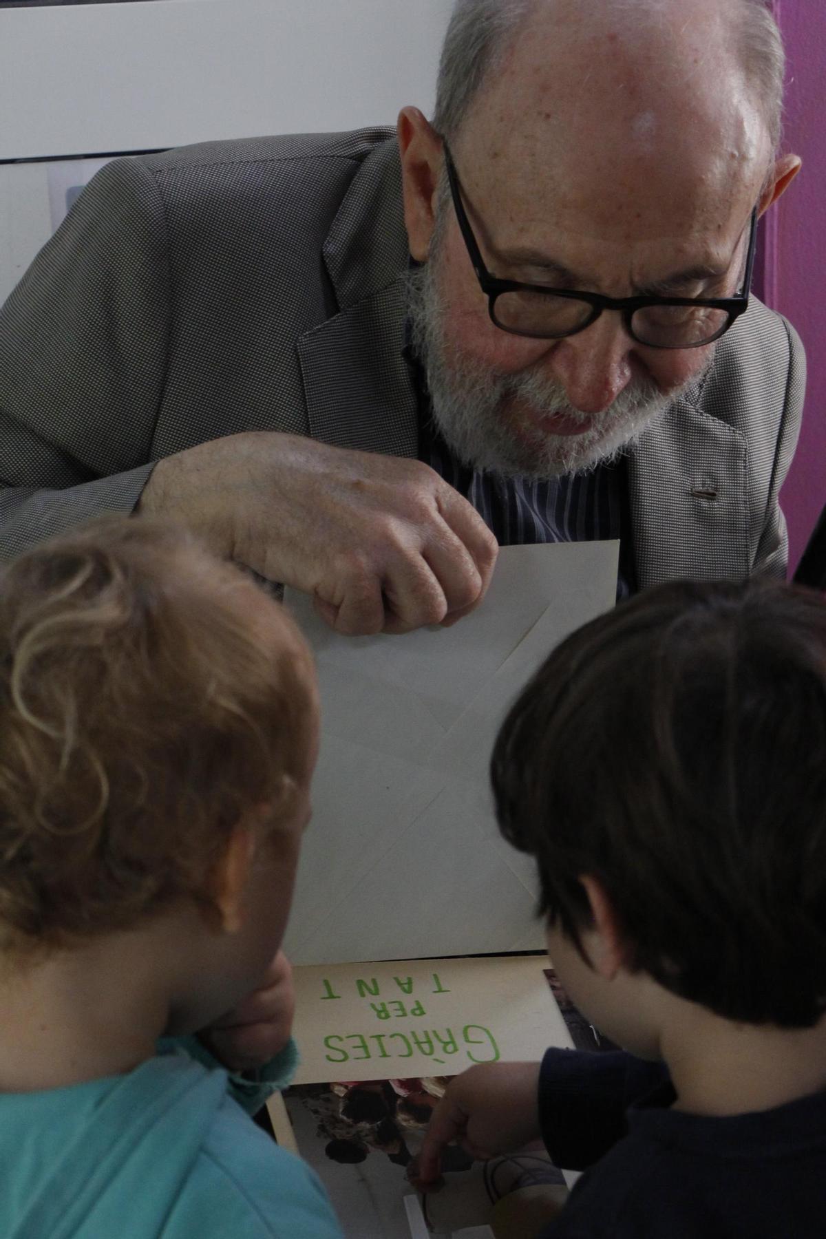 Marc Granell, al recital dels seus poemes per part de l'alumnat de l'Escoleta el Trenet i del CEIP 8 de Març de Patraix, rep emocionat un regal de la xicalla.