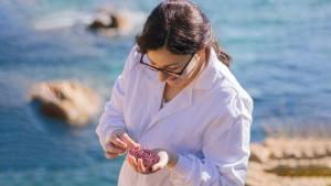 María Cermeño, cofundadora de Poseidona, analitza unes algues al costat del mar.