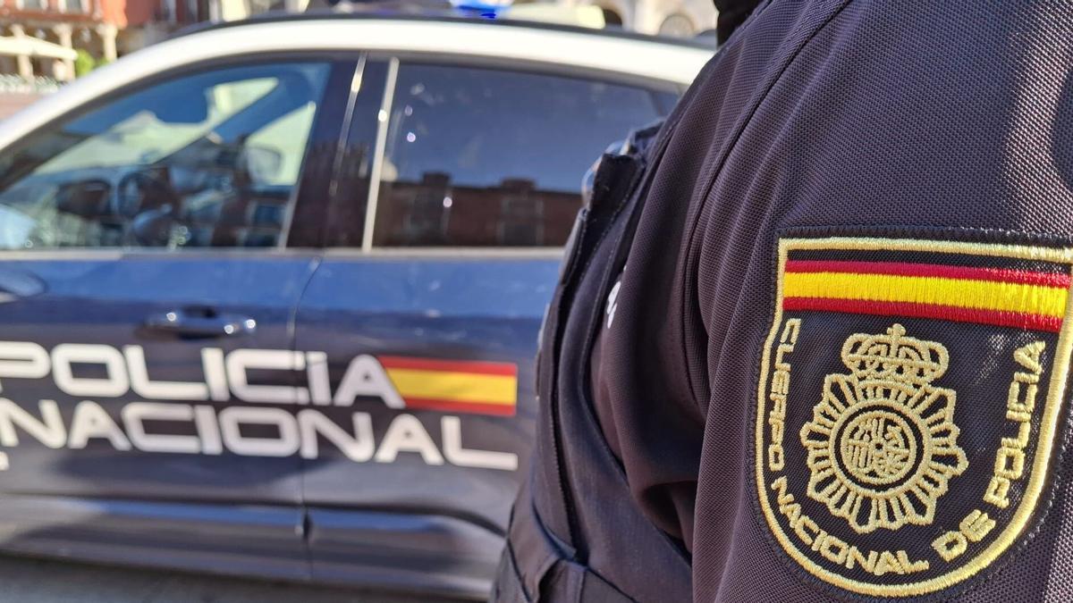 Imagen de archivo de la un agente de la Policía Nacional junto a su coche patrulla.