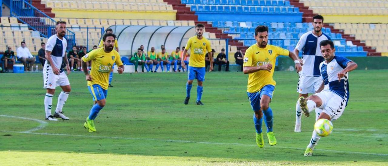 Los jugadores del Orihuela y el Sabadell en plena disputa por el balón con la grada de preferencia al fondo, precintada y cerrada al público por seguridad por los daños de la gota fría.