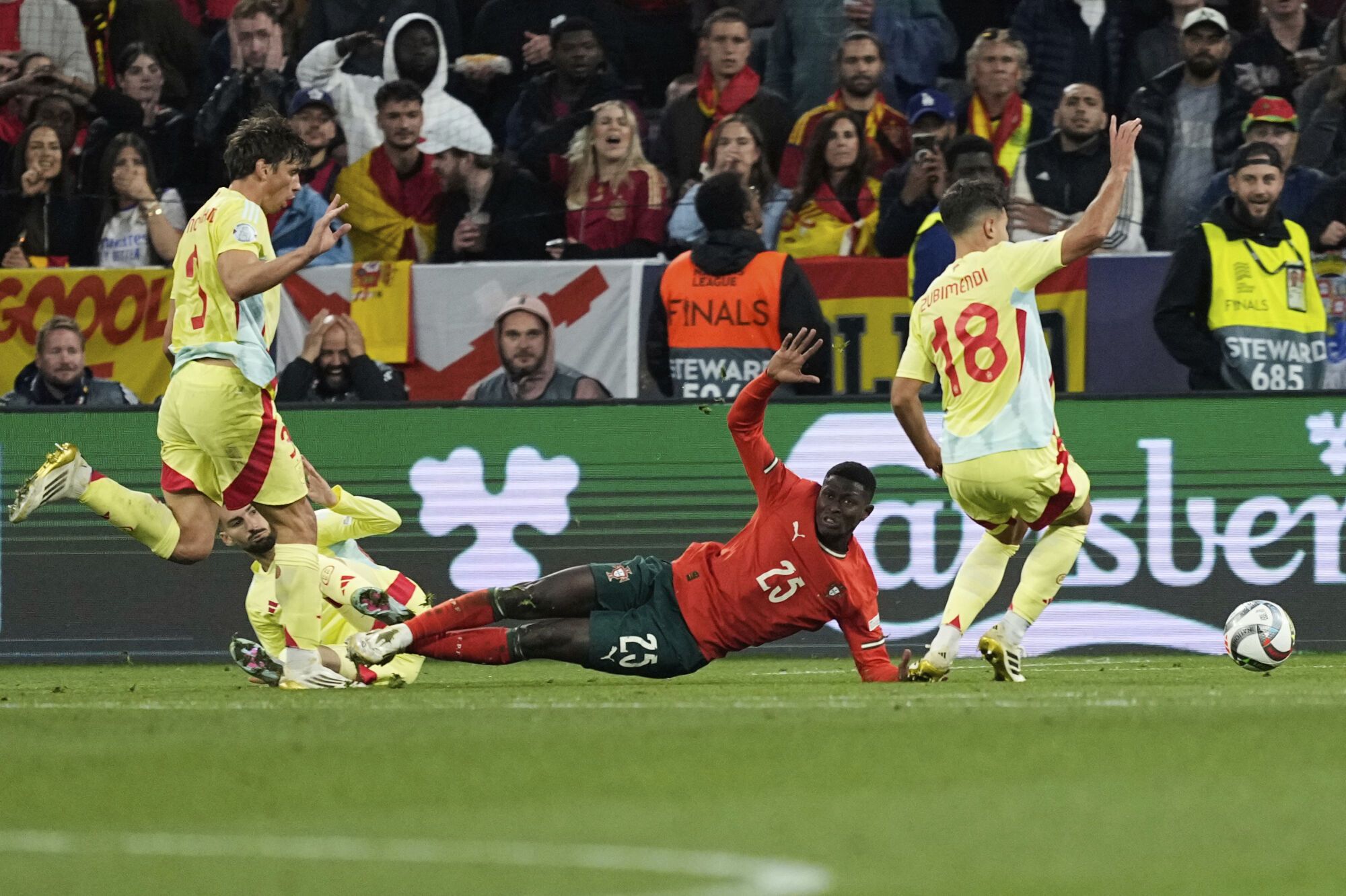 Portugal's Nuno Mendes, bottom, is challenged by Spain's Alex Baena during the Nations League final soccer match between Portugal and Spain at the Allianz Arena in Munich, Germany, Sunday, June 8, 2025. (AP Photo/Martin Meissner). EDITORIAL USE ONLY/ONLY ITALY AND SPAIN