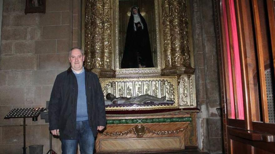 El párroco de Pola de Siero, Sergio Martínez, posando ayer junto a las imágenes del Cristo Yacente y la Virgen Dolorosa.
