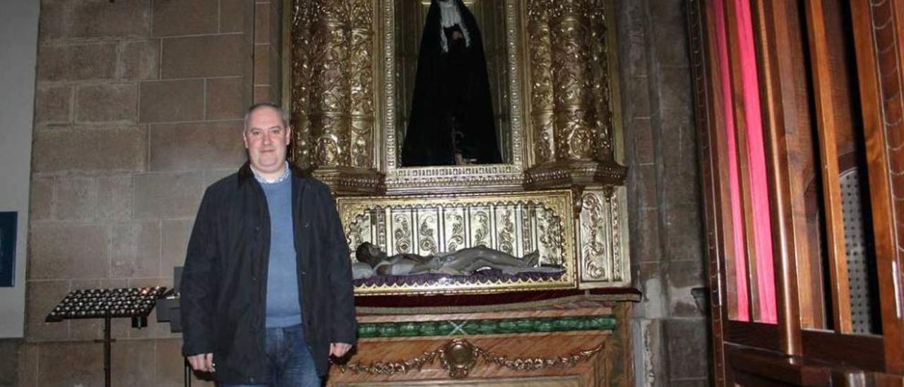 El párroco de Pola de Siero, Sergio Martínez, posando ayer junto a las imágenes del Cristo Yacente y la Virgen Dolorosa.