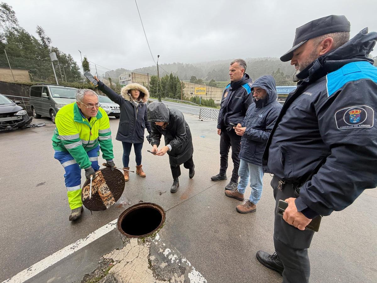 Operarios de mantenimiento levantando alcantarillas del taller en presencia de personal del Concello, la Xunta, la UTE y Policía Local.