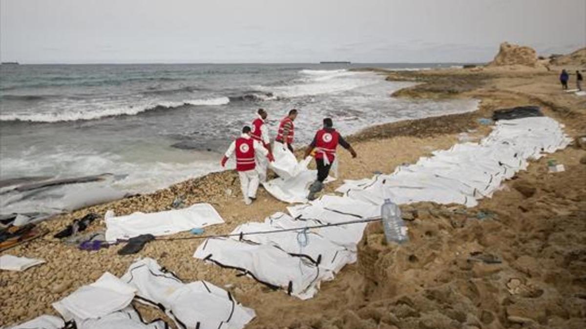 Decenas de cuerpos sin vida de inmigrantes alineados en una playa de Zawiya, ayer.