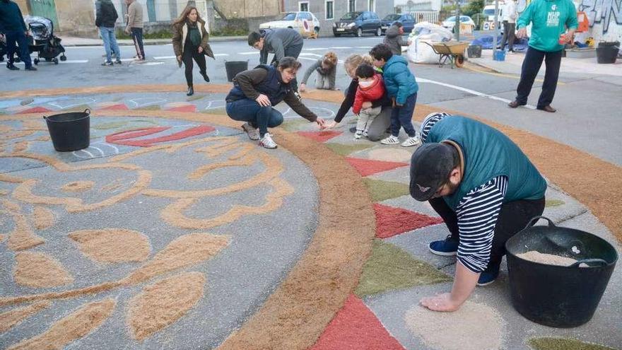 Elaboración de los alfombrados florales que hoy recibirán al desfile de la comunión pascual. // R. Vázquez