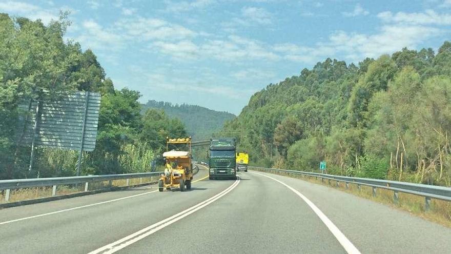 Maquinaria realizando el pintado amarillo de la señalización horizontal para iniciar la ampliación del corredor en el tercer subtramo, entre meira y el primer enlace de Cangas. // S.A.