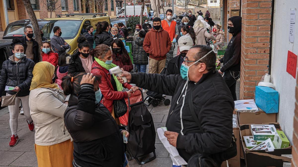 Una treintena de familias hacen cola para acceder al centro de distribución de alimentos de Trinitat (Nou Barris), gestionado por Cáritas.