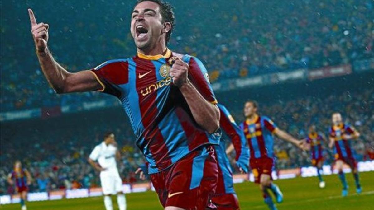 Xavi celebra el gol que consiguió ante el Madrid agarrándose el escudo de la camiseta.