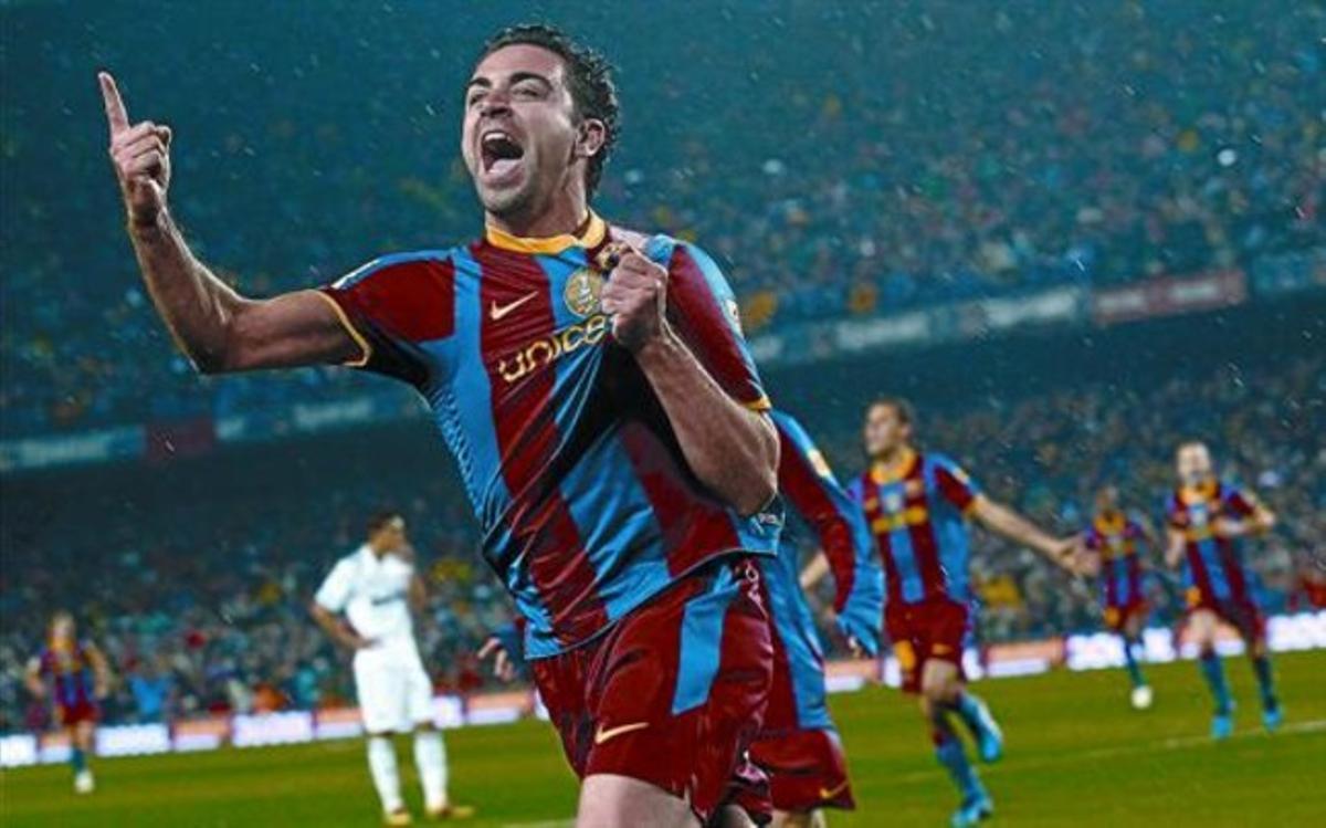 Xavi celebra el gol que va aconseguir davant el Madrid agafant-se l’escut de la samarreta.