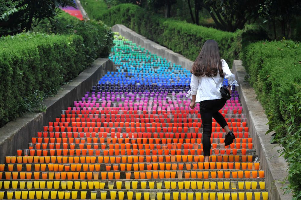 Una mujer sube unas escaleras llenas con vasos de plástico, un proyecto de cuatro estudiantes universitarios en Wuhan, China.