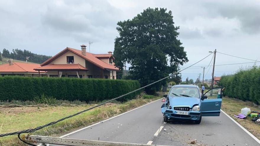 El poste que derribó el coche y que atravesó toda la calzada.