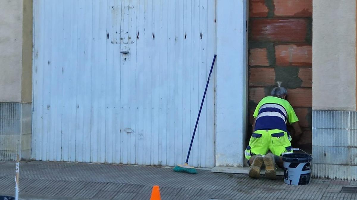 Un operari de la Brigada Municipal de Llagostera tapiant l'entrada.