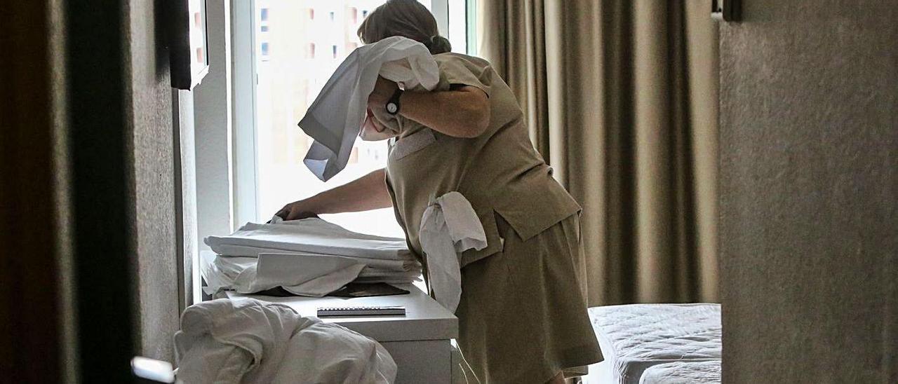 Una camarera de piso trabajando en la habitación de un hotel.