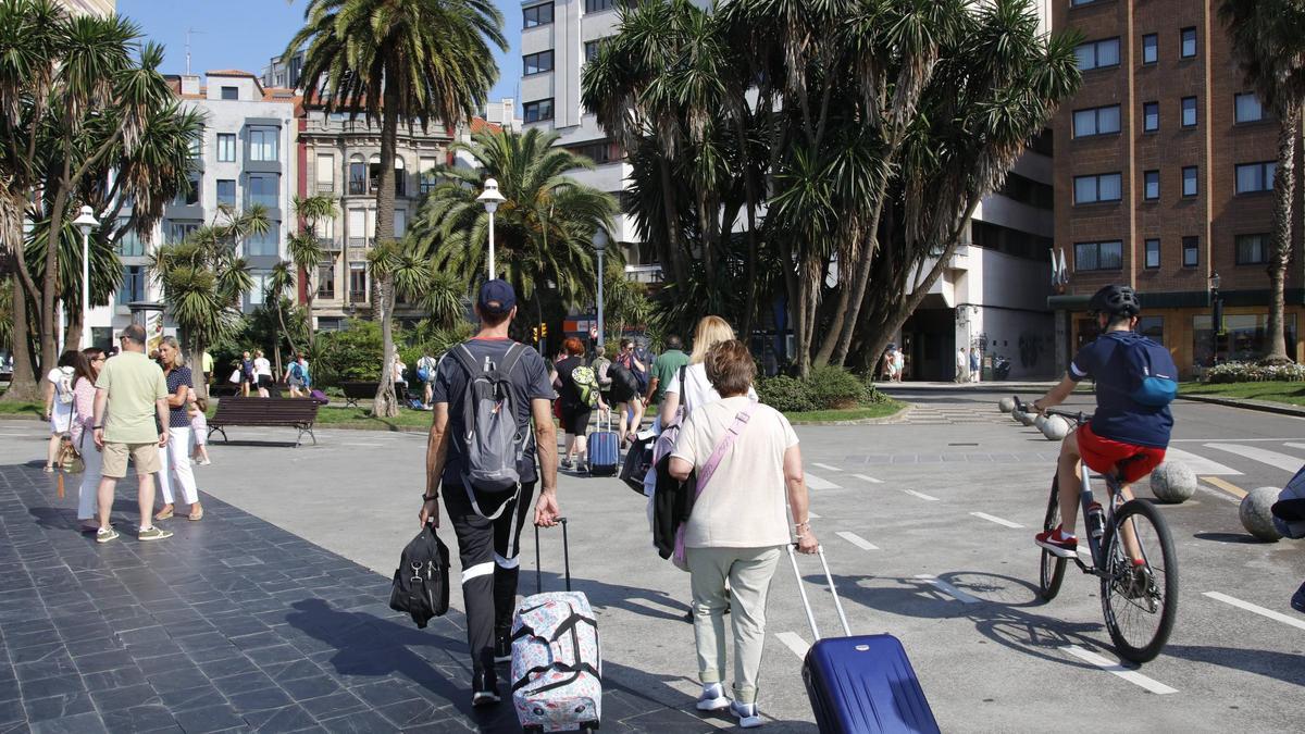 Turistas con maletas en los Jardines de la Reina.