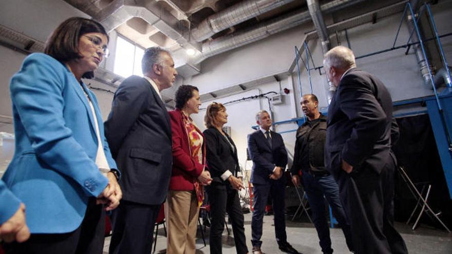 La ministra y el presidente atienden a las explicaciones de los trabajadores.