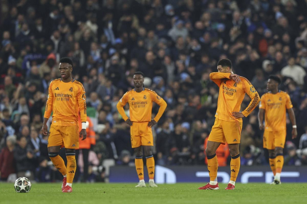 Real Madrids Vinicius Junior, left, and Real Madrids Jude Bellingham, right, react after Manchester Citys Erling Haaland scored the opening goal during the Champions League playoff first leg soccer match between Manchester City and Real Madrid at the Etihad Stadium in Manchester, England, Tuesday, Feb. 11, 2025. (AP Photo/Darren Staples)