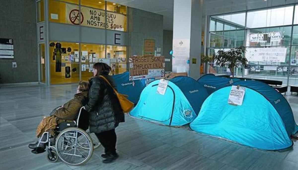 Uns usuaris passen davant les tendes instal·lades per personal de l’hospital de Sant Pau, ahir.