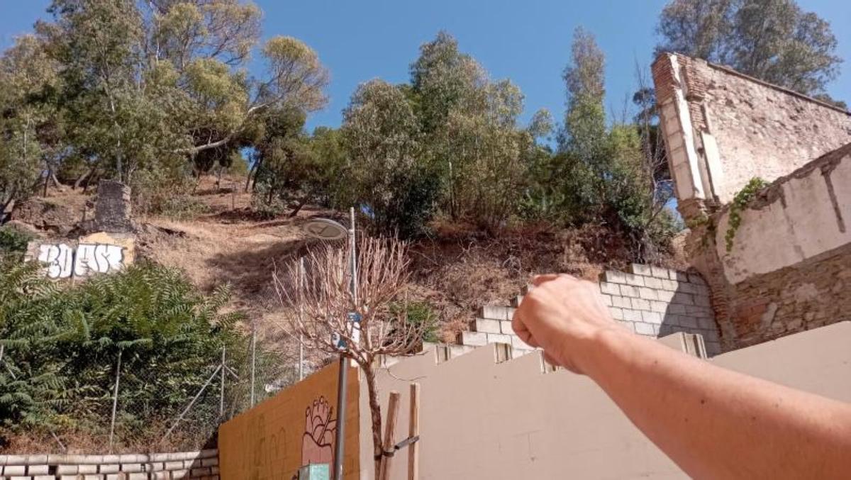 Por este muro de un solar público acceden al jardín privado de un bloque de la calle Picacho.