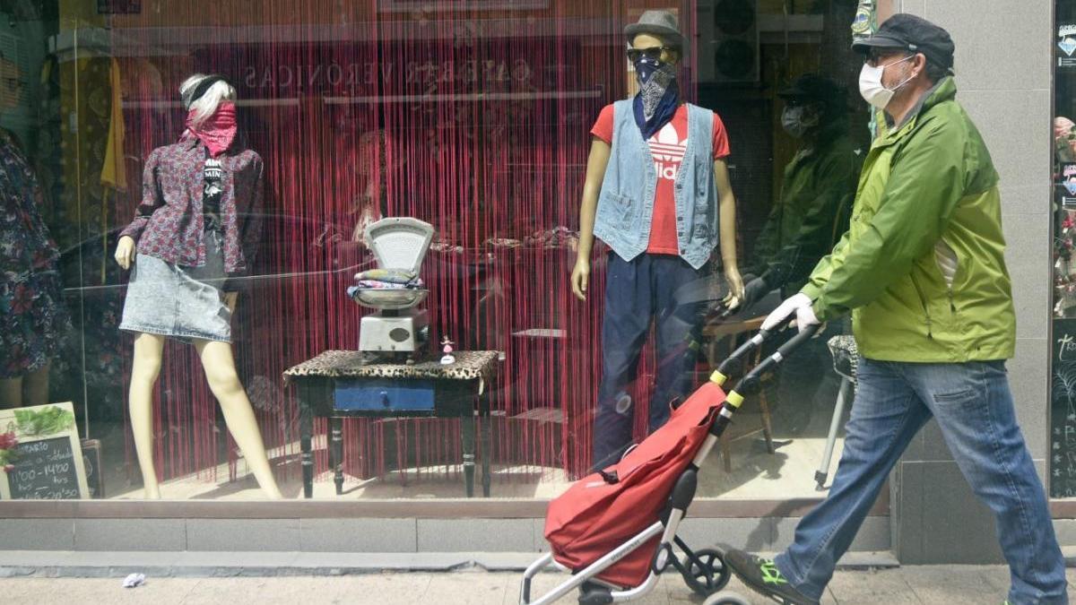 Una persona pasa frente a un escaparate en Murcia.