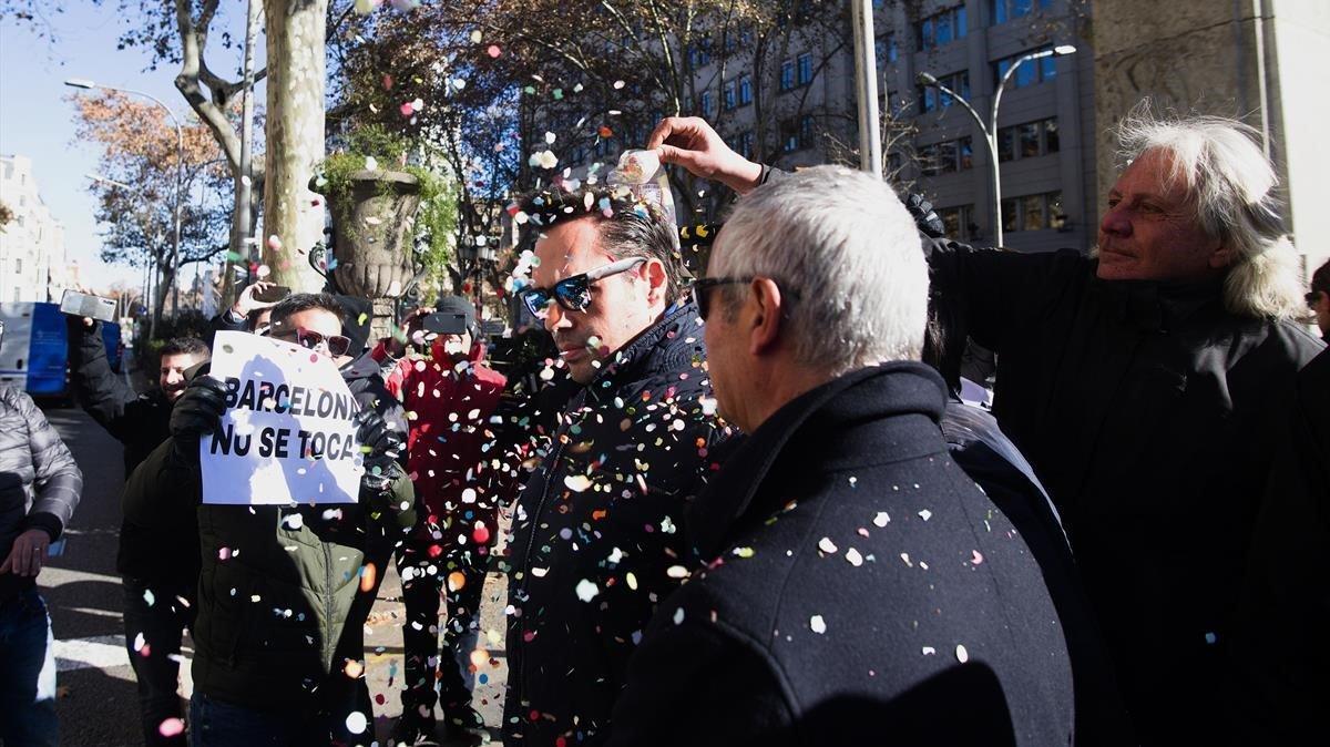 Eduardo Martin  responsable de  Unauto asociacion de vehiculos con conductor aguanta pacientemente la lluvia de confetis que le lanzan los taxistas en Barcelona.