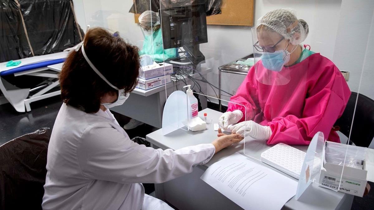 Una enfermera hace un test rápido a una mujer para ver si es portadora del coronavirus