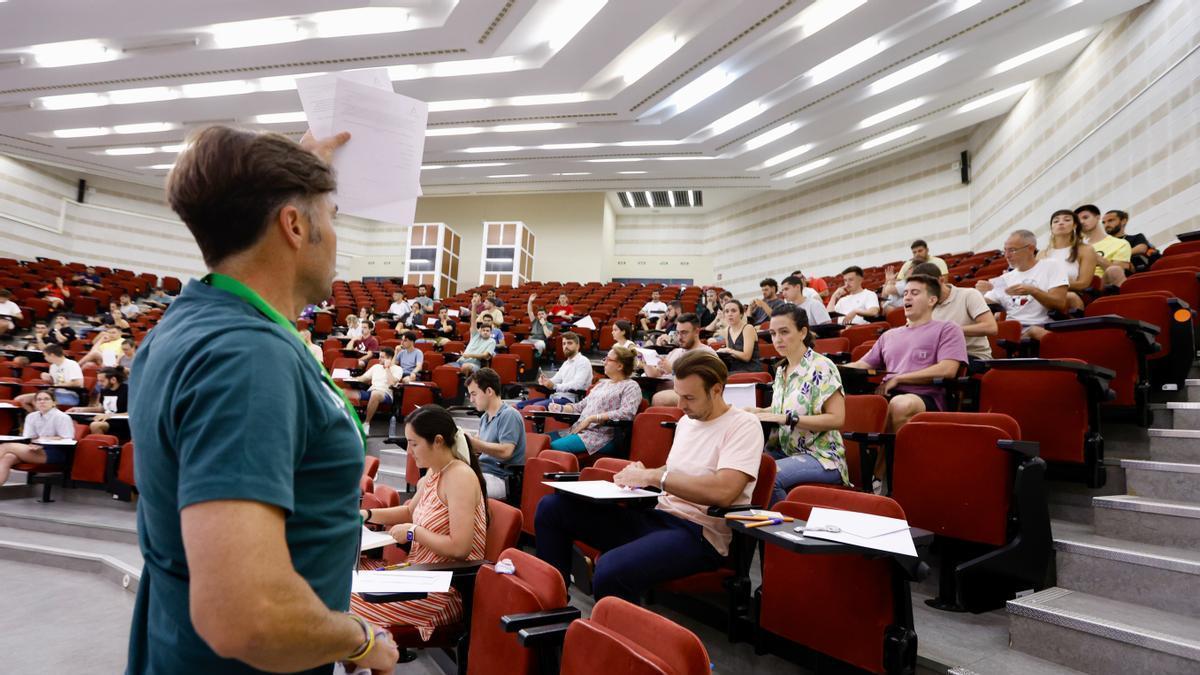 Un supervisor muestra el examen de la oposicón a un grupo de aspirantes.
