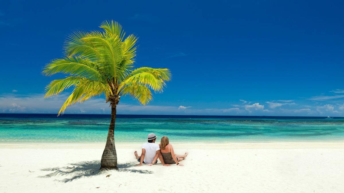 Pareja sentada en el Caribe