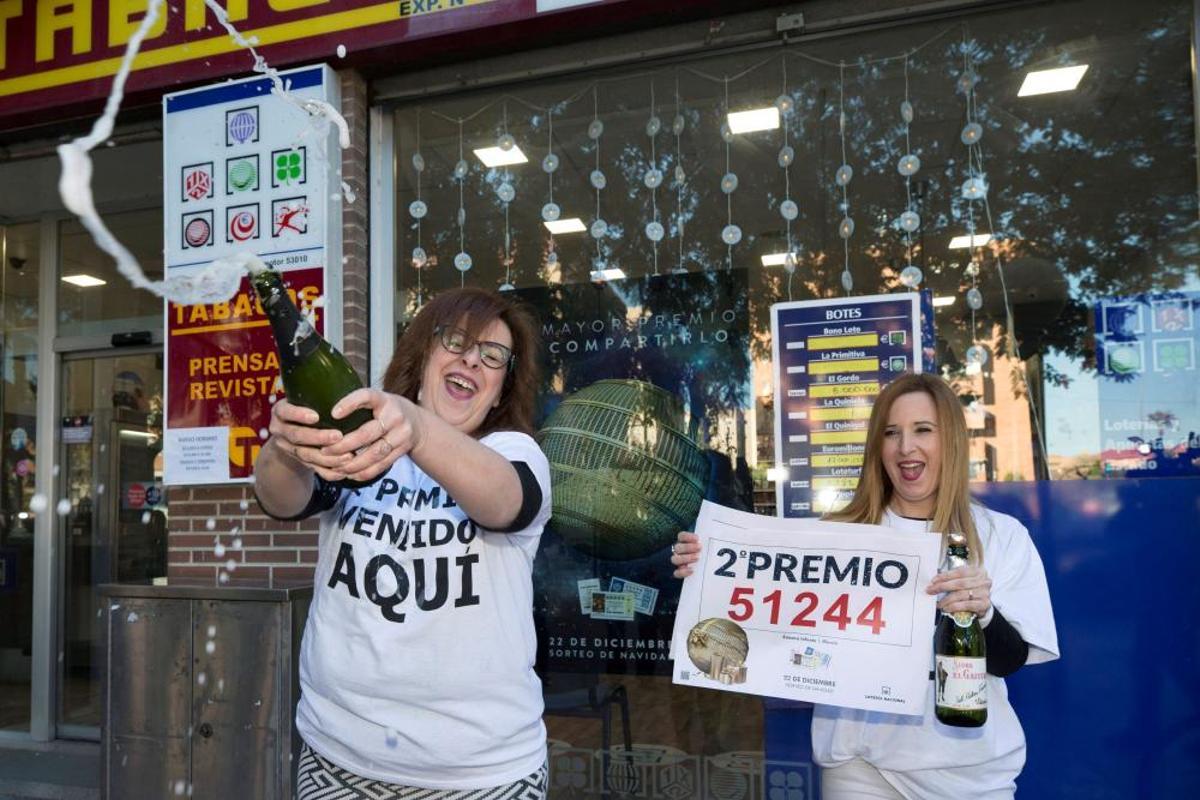 Las empleadas del punto receptor de loterías número 53.010 de la calle Pintor Almela Costa de Murcia, Esther Jaén (i) y Yolanda Leal (d) celebran la venta de un décimo del segundo premio el 51.244 premiado con 125.000 euros. EFE