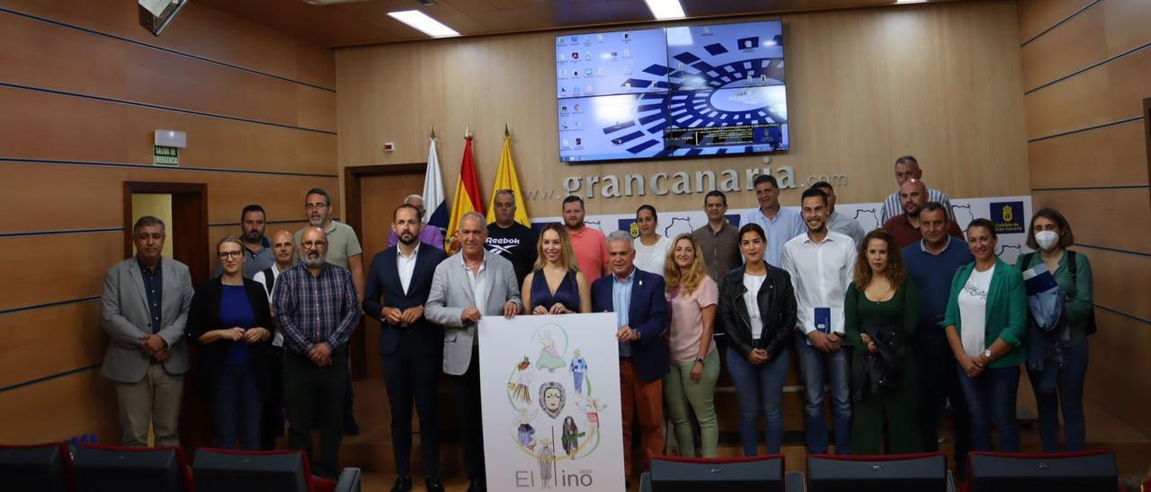 La representación de los municipios y el Cabildo, ayer, durante el sorteo de las carretas, junto al cartel de las fiestas del Pino. |