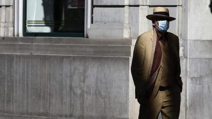 Un hombre pasea por el Centro de Málaga llevando la correspondiente mascarilla.