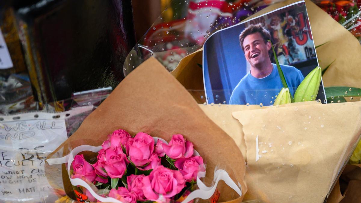 Flors i fotos en record de Matthew Perry, davant l'edifici de Nova York on se situava la història de Friends