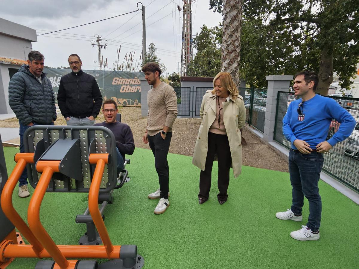 La alcaldesa y los concejales observan a un deportista en una de las máquinas