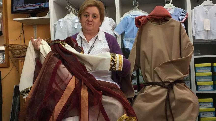 Mari Paz Llano, con algunos de los vestidos que diseñó para la representación del cuarto vía crucis viviente de Infiesto.