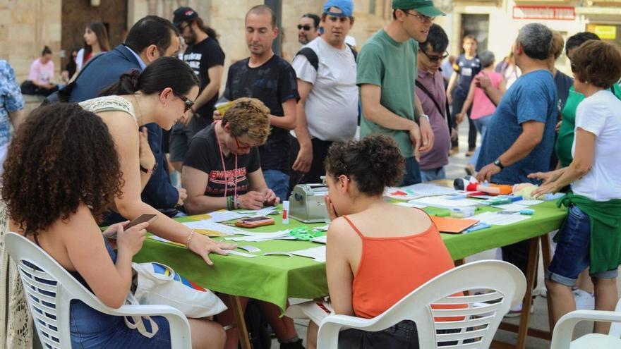 1-Asistentes al taller de braille. 2-Presentación del poemario de Rolando Kattan. 3-Público en distintas casetas. 4- Una mujer se interesa por un título. | ALBA PRIETO