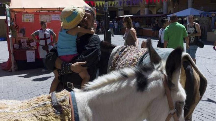 Uno de los actores participantes en el espectáculo abraza a un niño. Al fondo, uno de los puestos del zoco que ayer cerró sus puertas.