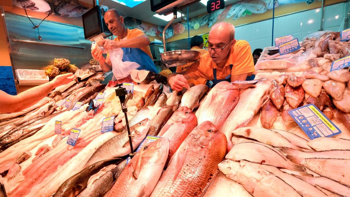 Dos pescaderos atienden a sus clientes en un comercio de la capital grancanaria.