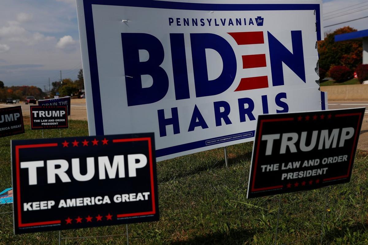 Campaign signs for U.S. Democratic presidential candidate Joe Biden and Vice presidential candidate Kamala Harris stand with signs for U.S. President Donald Trump on a hillside in Monroeville, Pennsylvania, U.S., October 21, 2020.  REUTERS/Shannon Stapleton
