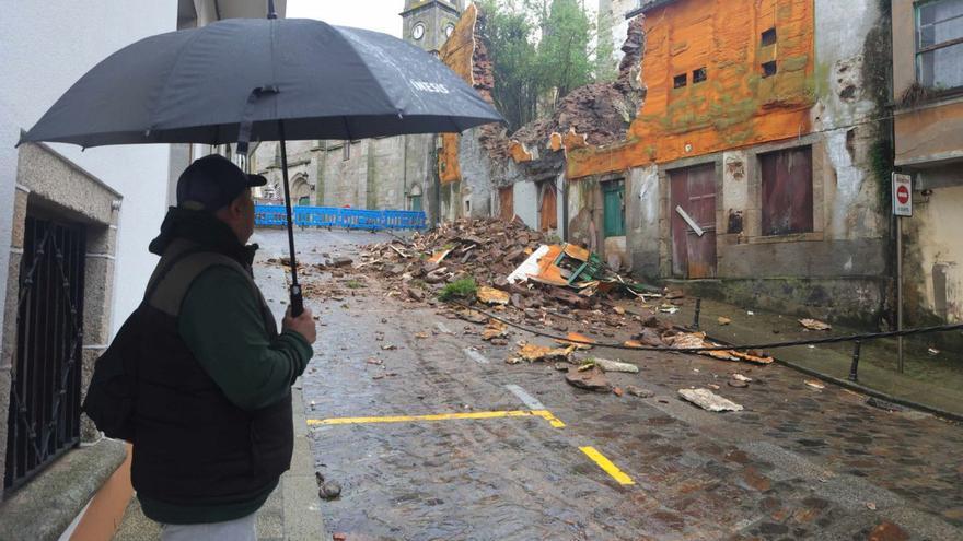 Un hombre observa el derrumbe que se registró en marzo en un edificio de Rúa Santiago. |   // IAGO LÓPEZ