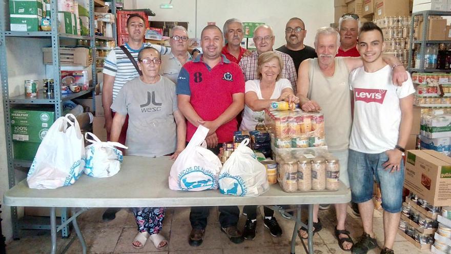Curro López, esta semana con algunos de los voluntarios en el almacén de la asociación de vecinos.