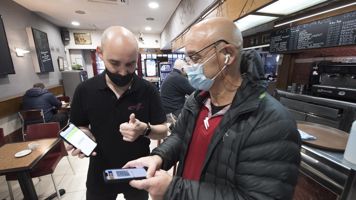 Un client mostra el certificat covid a la granja Alpina de Manresa