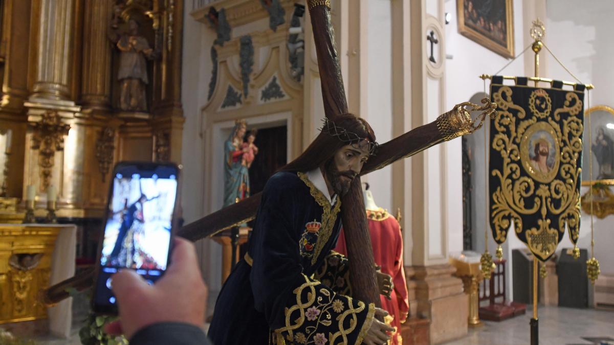 Una persona hace una foto al Cristo de los Toreros, este Viernes de Dolores en San Nicolás.