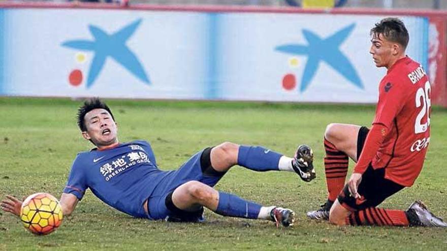 Brandon y un jugador del Shenshua luchan por el balón.