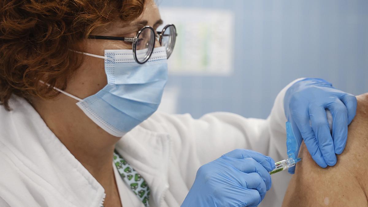 Una enfermera vacuna  frente a la gripe y el covid