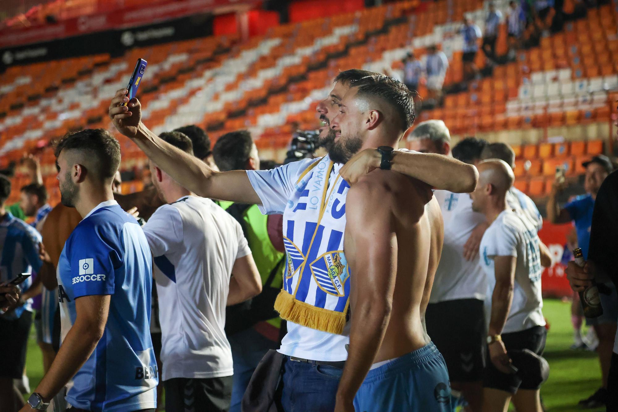 Los más de 500 aficionados del Málaga CF que estuvieron en el Nou Congost celebraron con los jugadores el épico ascenso a Segunda tras el final del partido