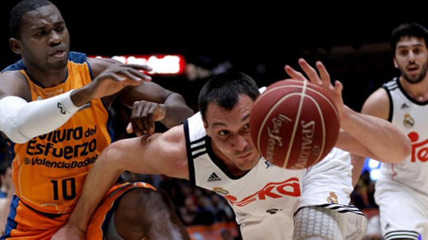 Maciulis, del Madrid, trata de coger un balón ante Sato.