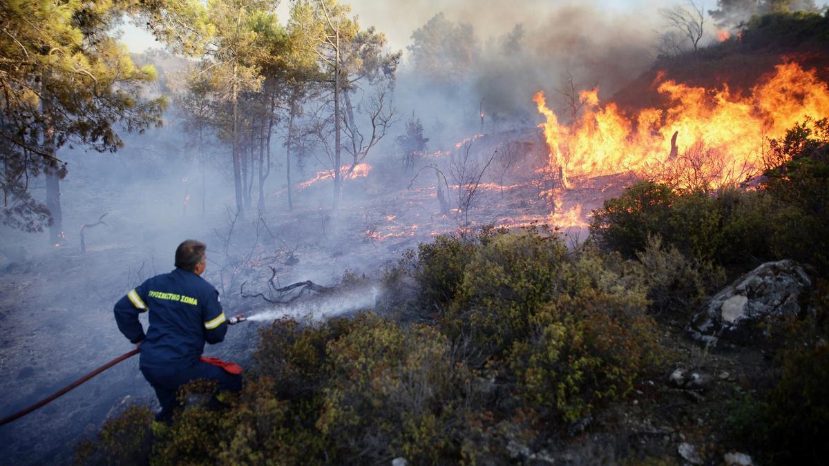 Lucha contra el fuego en Asklipio, en Rodas, donde residentes y más de 70.000 turistas han sido evacuados.