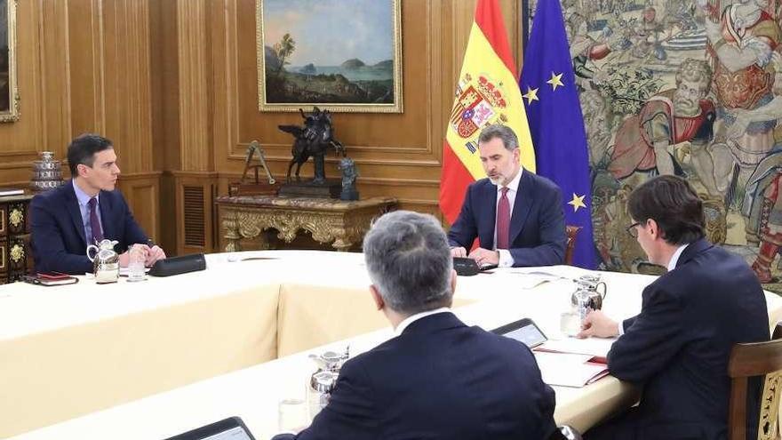 El monarca con Sánchez, Marlaska e Illa, en al gabinete de crisis. // Europa Press