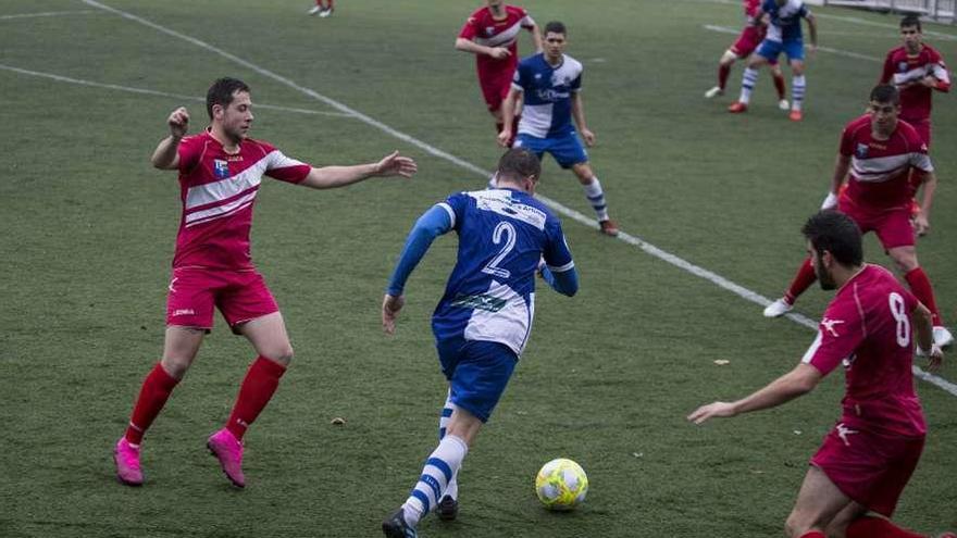 Dani Hevia conduce el balón entre varios rivales en el partido contra el Vallobín.